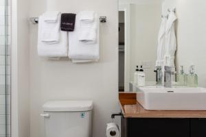 a bathroom with a sink and a toilet and towels at Hotel Leo in Bellingham