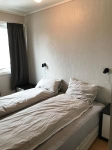una camera con due letti con lenzuola bianche e una finestra di Comfortable 3 bedroom Apartment on one floor. a Sandefjord