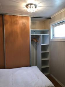 een slaapkamer met een kast met een bed en een raam bij Comfortable 3 bedroom Apartment on one floor. in Sandefjord