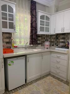 a kitchen with white cabinets and a sink and a window at Şehri ala evleri in Kutahya