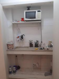 una cocina con microondas en un estante con fregadero en Apê Minimalista Melhor do Centro Self check-in, en Río de Janeiro