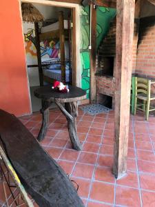 una habitación con una mesa y un banco en una habitación en Amarelo Hibisco, en Guarda do Embaú