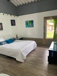 a bedroom with a large bed and a window at Moderna cabaña en medio de la naturaleza in Santandercito