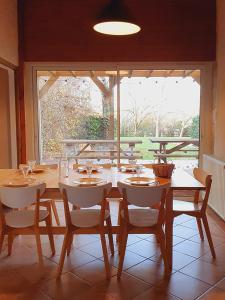a dining room with a table and chairs and a window at Domaine de la Brette in Condom