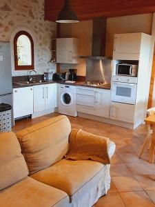 a kitchen with a couch in the middle of a room at Domaine de la Brette in Condom