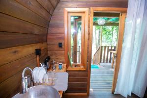 eine Küche mit einem Waschbecken und eine Tür zur Veranda in der Unterkunft ALQUIMIA Hospedaria in Praia do Forte