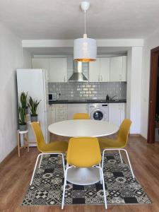 una cucina con tavolo bianco e sedie gialle di Anka Talo a El Médano