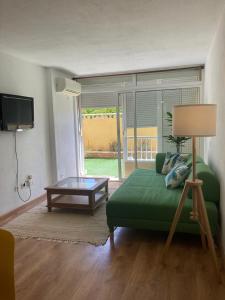 un soggiorno con un divano verde e un tavolo di Anka Talo a El Médano