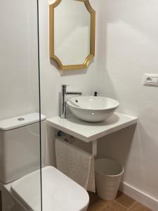 un bagno bianco con lavandino e specchio di Anka Talo a El Médano