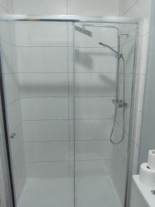 y baño con ducha y puerta de cristal. en Piccadilly Apartments, en Bradford