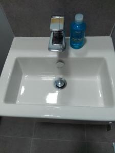 a white sink with a bottle of mouthwash on it at Piccadilly Apartments in Bradford