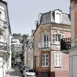 ulica miejska z samochodami zaparkowanymi obok budynków w obiekcie Au cœur de Trouville. Appartement de 3 pièces. w mieście Trouville-sur-Mer