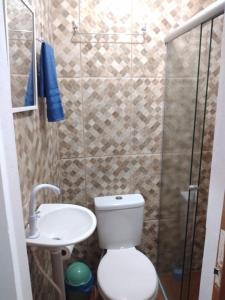 uma casa de banho com um chuveiro, um WC e um lavatório. em Pousada Recanto do Coruja em São Gabriel