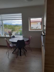 una sala da pranzo con tavolo, sedie e finestra di Bifröst a Bifrost
