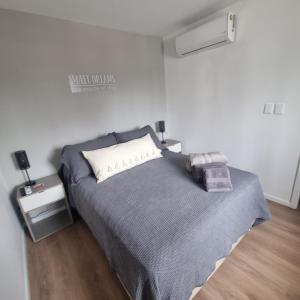 1 dormitorio con 1 cama con manta gris y mesita de noche en Exclusivo Penthouse en Cordon Soho con Parking y STARPLUS incluidos, en Montevideo