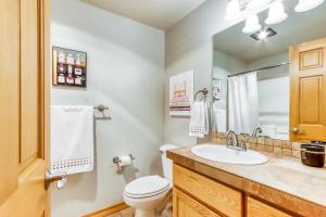 a bathroom with a sink and a toilet and a mirror at Lost Rider Loop Lodge in Sunriver +40 photos