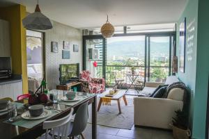 a living room with a couch and a table with chairs at Avitat Joy 2Brm Amazing City&Volcano View Pool&Gym in San Salvador