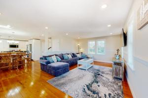 a living room with a blue couch and a kitchen at Bayberry Beauty in Nameloc Heights