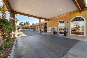 una pasarela frente a un edificio con palmeras en Best Western Mesquite Inn, en Mesquite