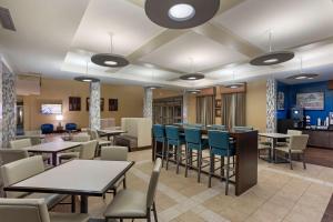 a restaurant with tables and chairs and a bar at Best Western PLUS University Park Inn & Suites in State College