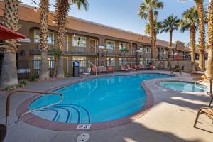 een zwembad voor een gebouw met palmbomen bij Best Western Mesquite Inn in Mesquite