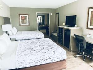 Habitación de hotel con 2 camas, escritorio y ordenador en Best Western - Fayetteville en Fayetteville