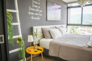 a bedroom with a bed and a table and a window at Avitat Joy 2Brm Amazing City&Volcano View Pool&Gym in San Salvador +46 photos