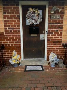 a front door of a brick house with wreaths on it at A Cozy Home Away From Home in Washington