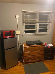 a room with a microwave and a dresser and a window at A Cozy Home Away From Home in Washington
