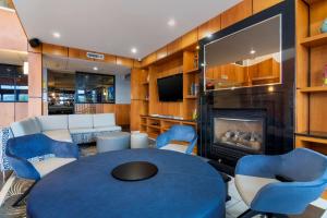 Best Western Premier Aberdeen Kamloops في كاملوبس: غرفة معيشة مع طاولة زرقاء وكراسي ومدفأة
