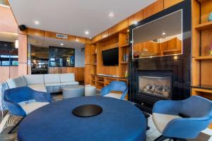 a living room with a blue table and chairs and a fireplace at Best Western Premier Aberdeen Kamloops in Kamloops