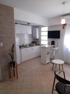 una cucina con armadi bianchi, tavolo e sedie di ApartRos a Rosario