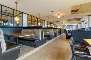 a restaurant with benches and tables and chairs at Best Western Premier Aberdeen Kamloops in Kamloops