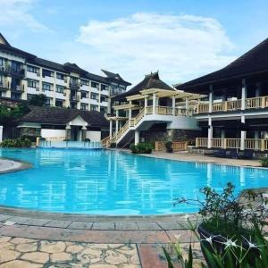 a large swimming pool in front of a building at Cozy 2BR with FREE Pool beside SM City Mall in Davao City