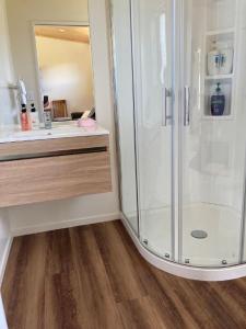 een badkamer met een douche en een houten vloer bij Country Retreats On Ranzau 4 in Hope
