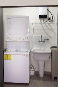 a small kitchen with a sink and a refrigerator at Avitat Joy 2Brm Amazing City&Volcano View Pool&Gym in San Salvador