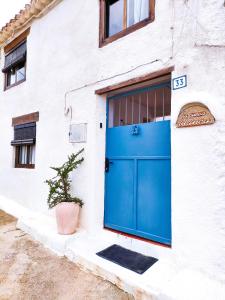 een blauwe deur aan de zijkant van een gebouw bij La Cueva Blanca in Alcalá del Júcar