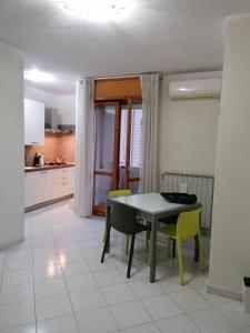 uma cozinha com uma mesa e cadeiras amarelas em Appartamento Bellavista em Pisa