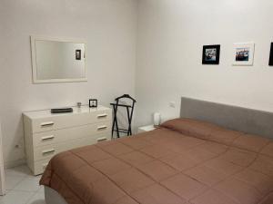 um quarto com uma cama, uma cómoda e um espelho em Appartamento Bellavista em Pisa