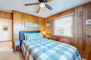 a bedroom with a bed and a ceiling fan at Dockside Landing in Nags Head