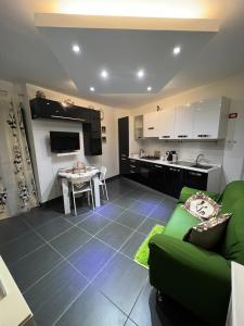Il comprend un salon avec un canapé vert et une cuisine. dans l'établissement Nel Cortile Suite, à Cefalù