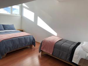 een slaapkamer met 2 bedden en een raam bij Casa Grande, Alojamiento "BSA" in Cochrane