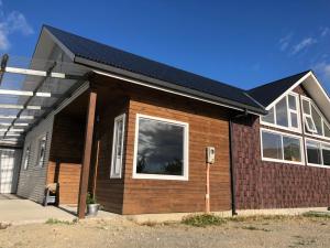 a brown house with a black roof at Casa Grande, Alojamiento "BSA" in Cochrane