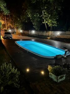 a blue swimming pool in a parking lot at night at Chalés no meu quintal in Lauro Müller