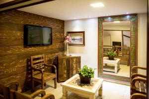 ein Wohnzimmer mit einem TV an einer Backsteinwand in der Unterkunft Hotel Fabris in Nova Friburgo