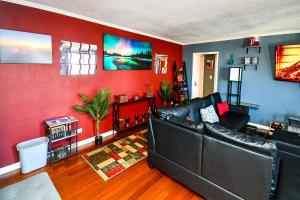 a living room with a leather couch and red walls at Modern Designed DTWN Condo with a 99 percent Walk Score in Atlanta +39 photos