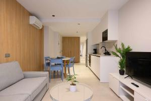 a living room with a couch and a table and a kitchen at Canteras Urban Beach in Las Palmas de Gran Canaria