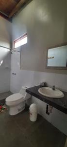 a bathroom with a toilet and a sink at Origenes Spa & Lodging in Vichayito
