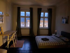 1 dormitorio con 1 cama, escritorio y 2 ventanas en Spokojny Sen Quiet Rooms in Old Town en Poznan