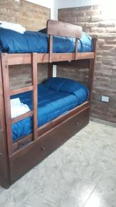 a couple of bunk beds with blue sheets on them at Complejo Puesta del Sol san Luis in La Punta